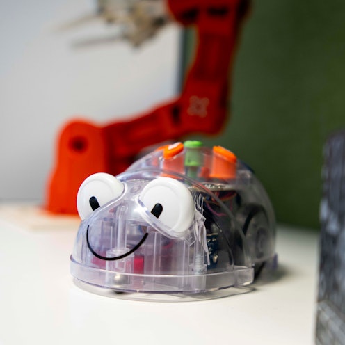 Das Bild zeigt einen kleinen Roboter, der mit wenigen Knopfdrücken programmiert werden kann. Er hat die Form einer Maus.