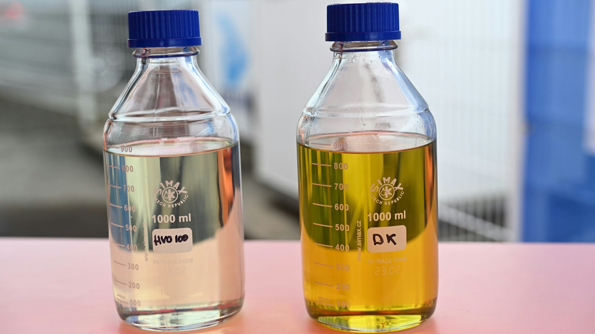Die beiden Kraftstoffe stehen abgefüllt in Flaschen nebeneinander auf einem Tisch.