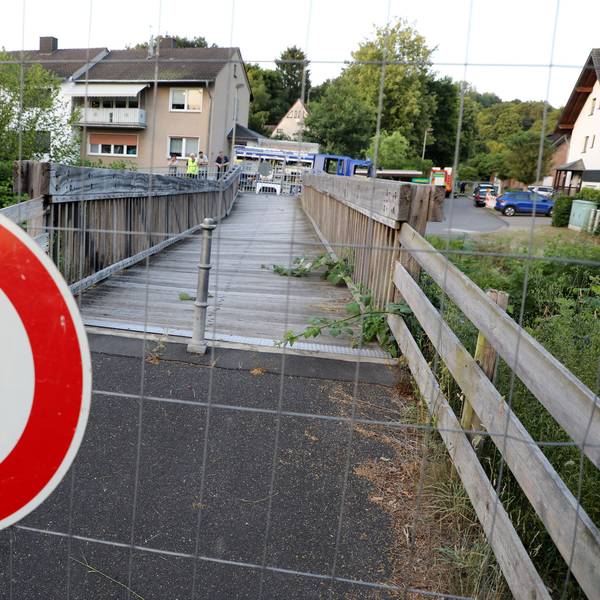 Ein Schild „Durchgang für Fußgänger verboten“ hängt an einem Bauzaun vor einer maroden Holzbrücke in Rösrath.