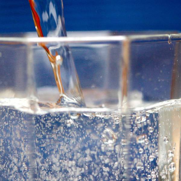 Sprudelwasser wird in ein Glas geschüttet.