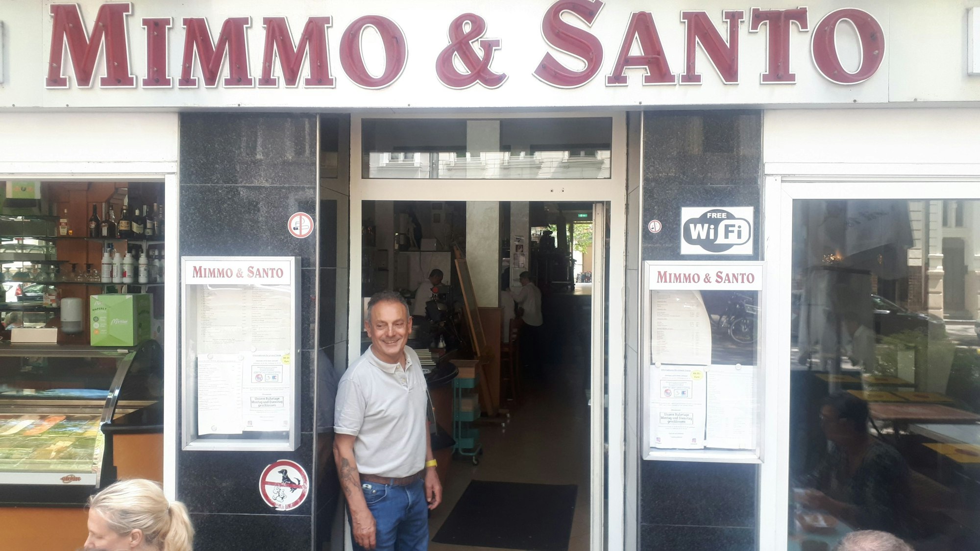 Ein Mann steht in der Tür seinen Restaurants.