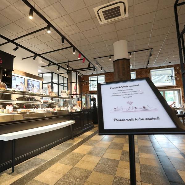 Ein in braun gehaltenes Café´ mit einer langen Kuchen- und Tortentheke.