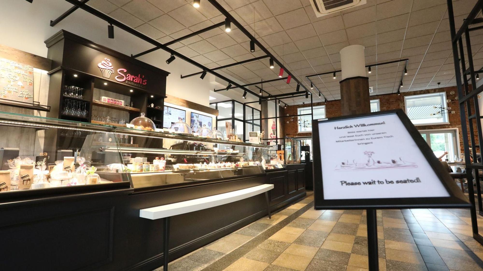 Ein in braun gehaltenes Café´ mit einer langen Kuchen- und Tortentheke.