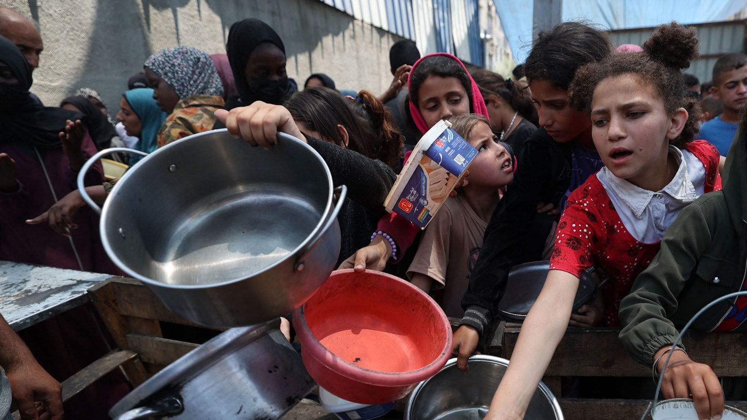 Kinder im Gazastreifen warten auf Essen an einem Verteilzentrum in Nuseirat.