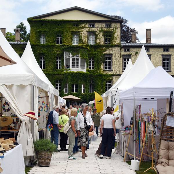 Pavillons mit Waren vor einer alten Villa.