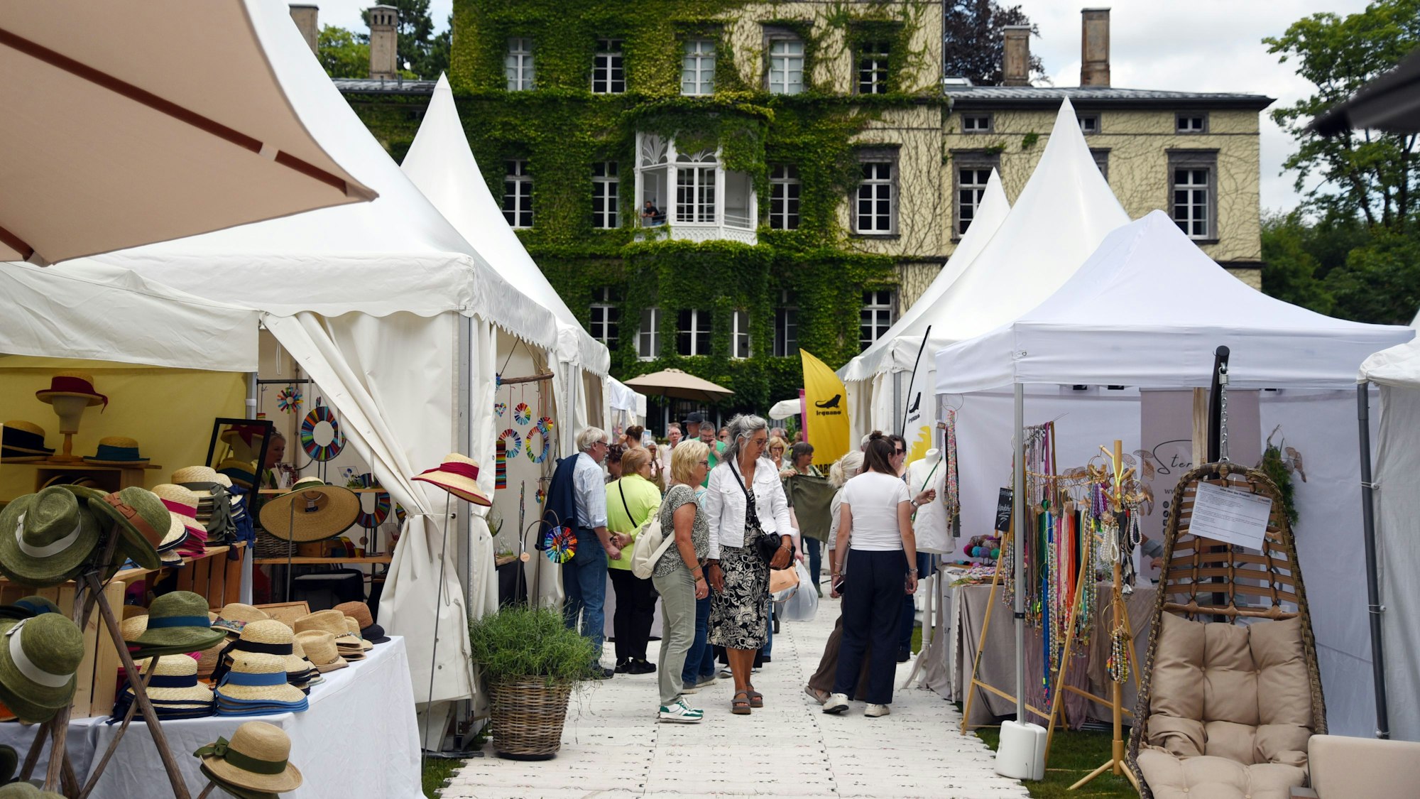 Pavillons mit Waren vor einer alten Villa.