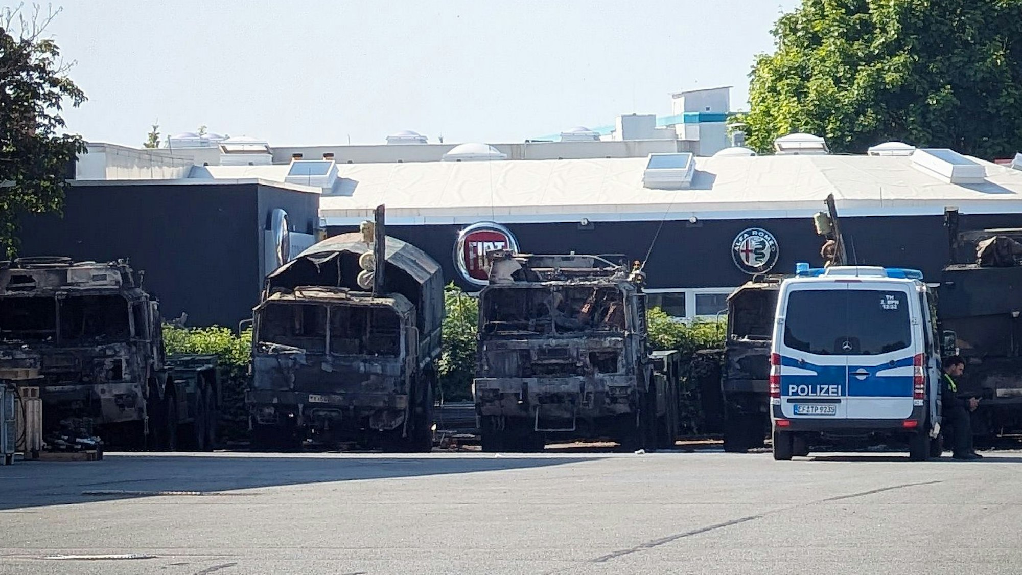 ARCHIV - 22.06.2025, Thüringen, Erfurt: Ein Polizeifahrzeug steht vor mehreren verbrannten Militärlastern auf dem Gelände eines Nutzfahrzeug-Serviceunternehmen. (zu dpa: «Russischsprachiges Video zu Brandanschlag auf Bundeswehr») Foto: Martin Wichmann/WichmannTV/dpa +++ dpa-Bildfunk +++