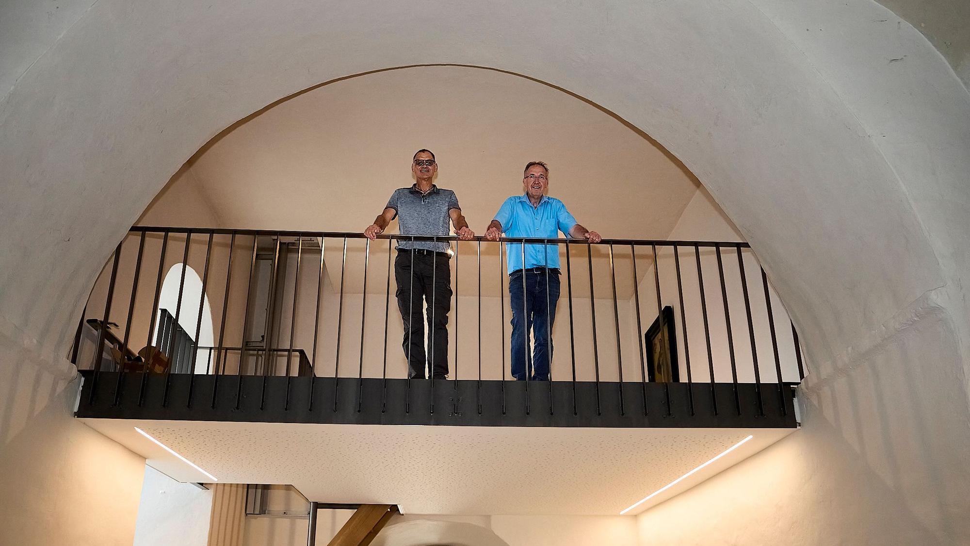 Herbert Faßbender (links) und Gregor Mauel stehen auf einer Empore in einer Kirche.