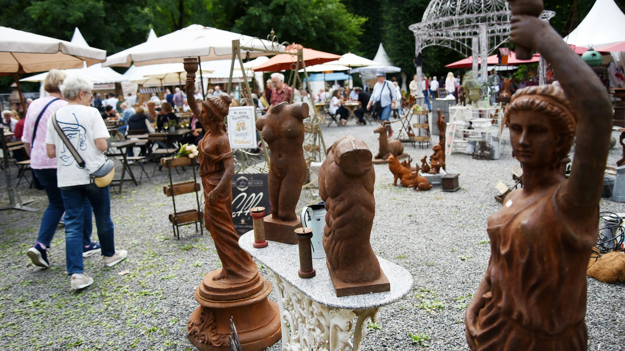 Zwei Frauen laufen an antikisierenden Statuen vorbei.