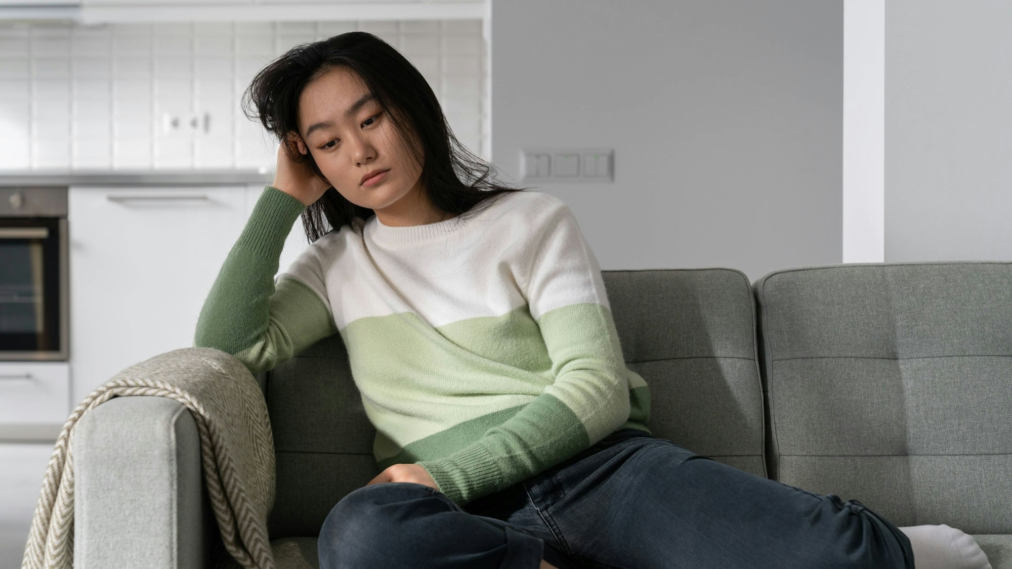 Traurige Frau sitzt auf dem Sofa