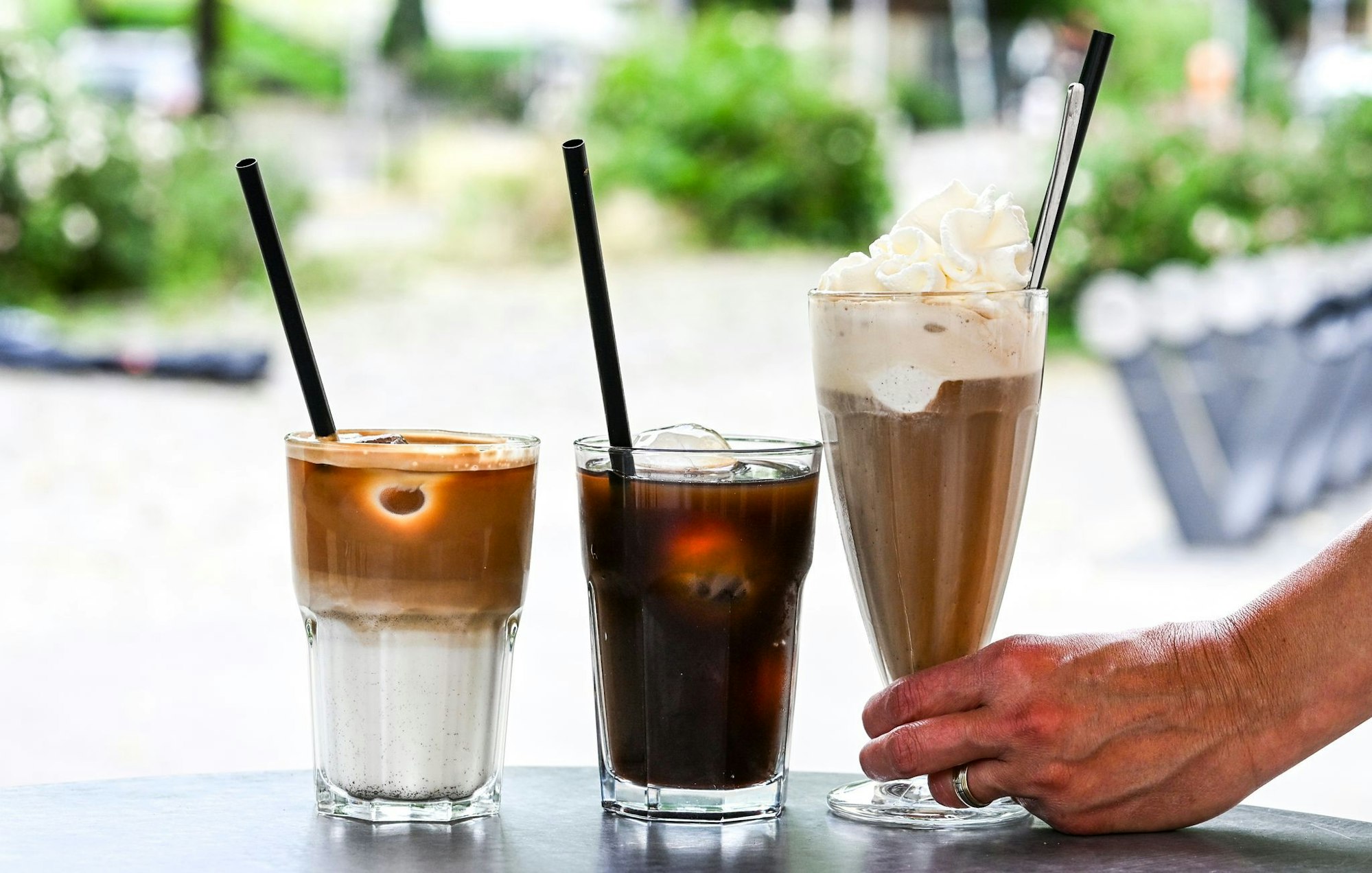 Iced Latte, Iced Coffee (also Kaffee mit Eiswürfeln) und klassischer Eiskaffee mit Vanilleeis und Sahne - präsentiert in einem Berliner Café.