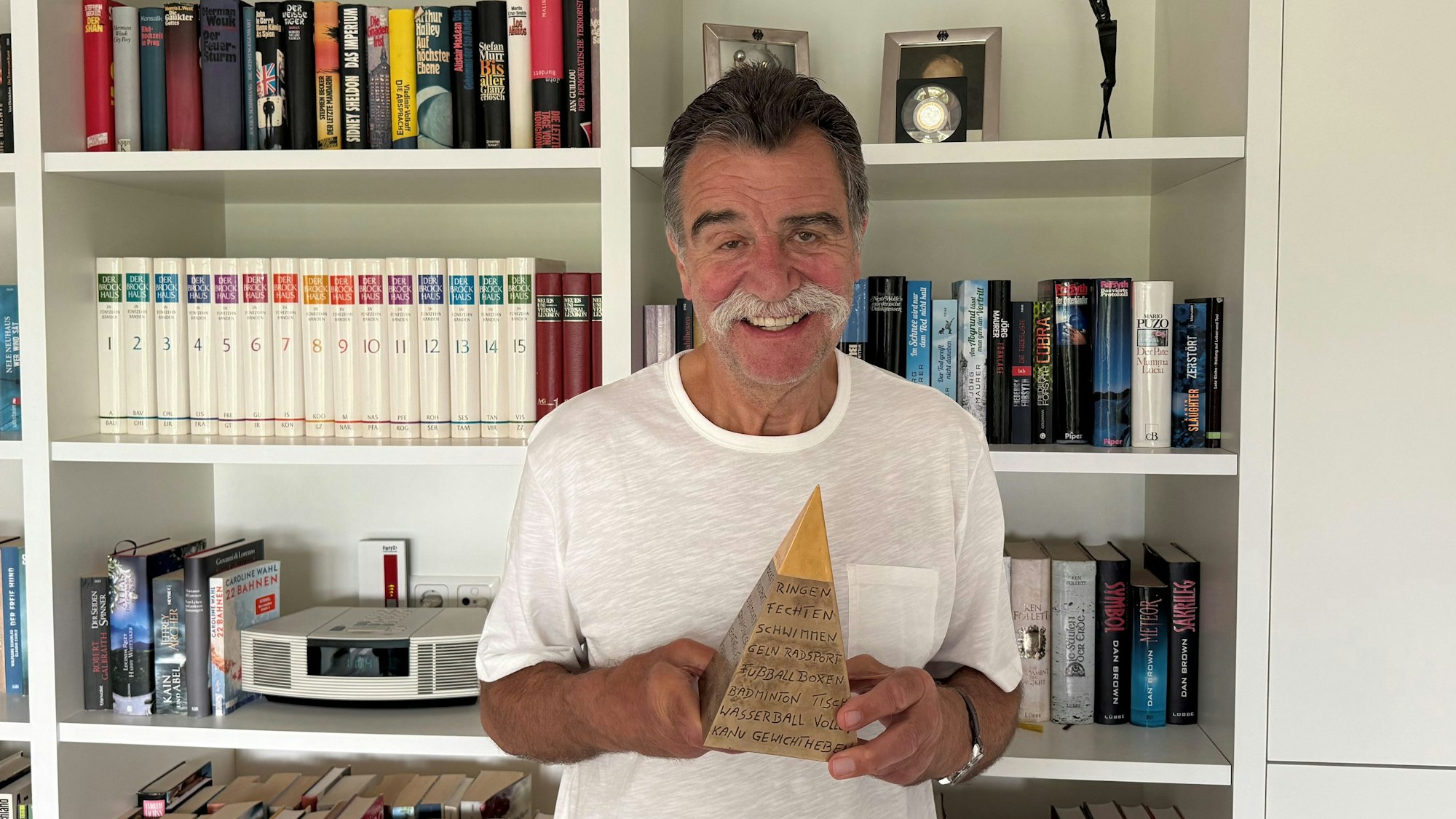 Heiner Brand präsentiert seine Goldene Sportpyramide.