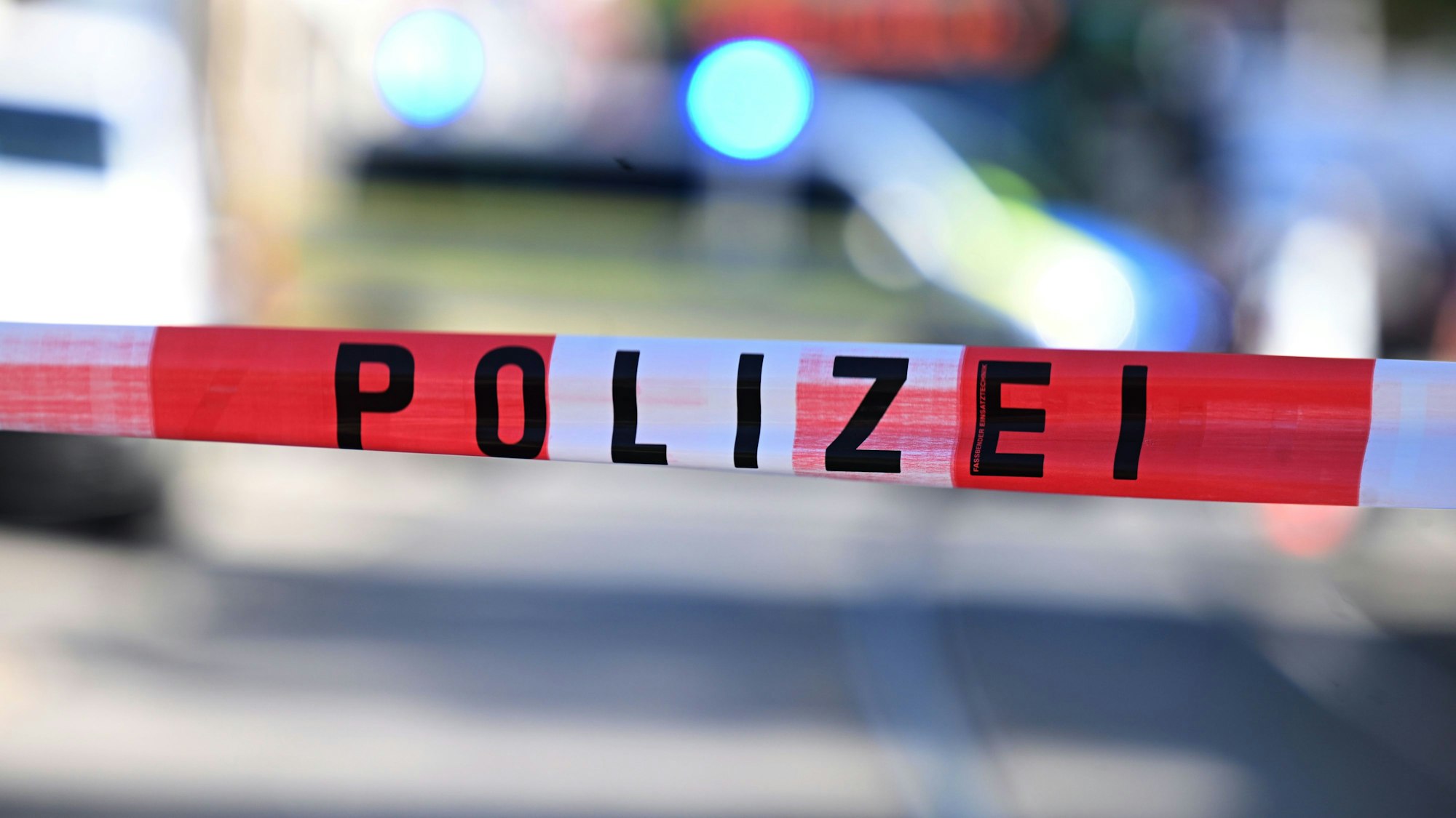 Ein Flatterband mit der Aufschrift „Polizei“ weht im Wind. (Symbolbild)