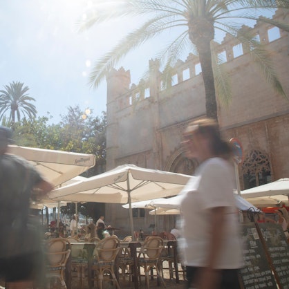 Menschen spazieren in der Innenstadt von Palma auf dem Platz Sa Llotja in Mallorca. Von Ende Mai bis zum kommenden Montag herrscht in Spanien eine frühlingshafte Hitzewelle mit Temperaturen über 40 Grad.