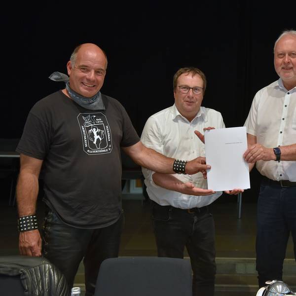 Stefan Voigt, Bürgermeister Karthaus und Ulrich Pahlke übergeben NRW-Umweltminister Oliver Krischer den Antrag zur Ausweisung als Nationales Naturmonument.