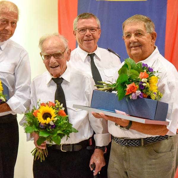 Vier Männer halten Blumen
