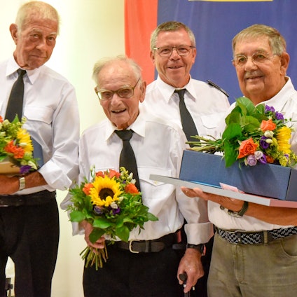 Vier Männer halten Blumen