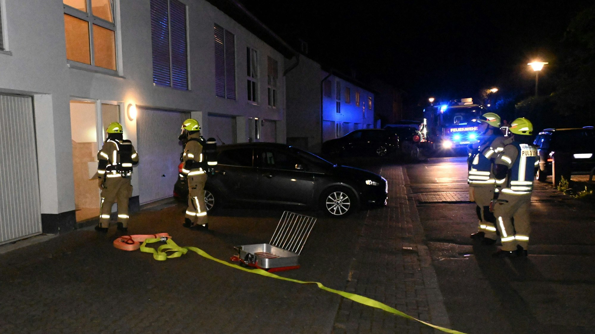 Auf dem Bild sind Feuerwehrleute bei einem nächtlichen Einsatz zu sehen.