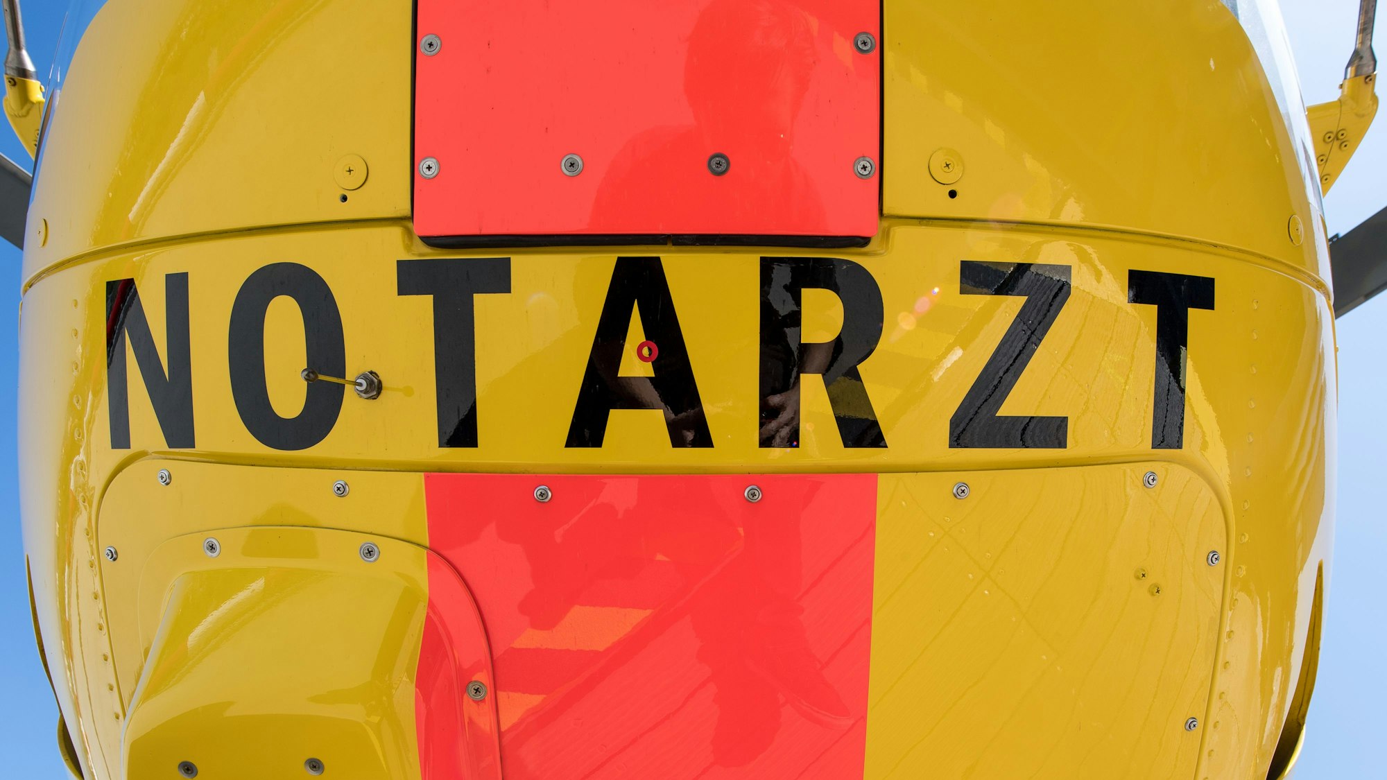 Auf der Unterseite eines Rettungshubschraubers steht die Aufschrift „Notarzt“.