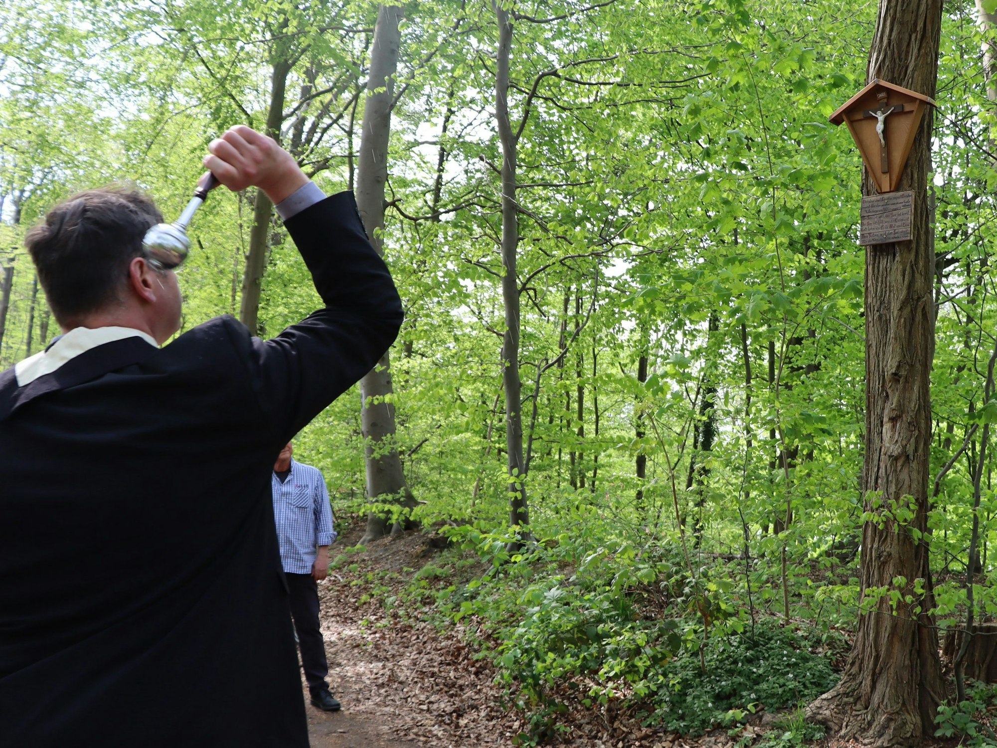 Das Bild zeigt Pfarrer Matthias Genster bei der Einsegnung im Wald am Berggeistsee.