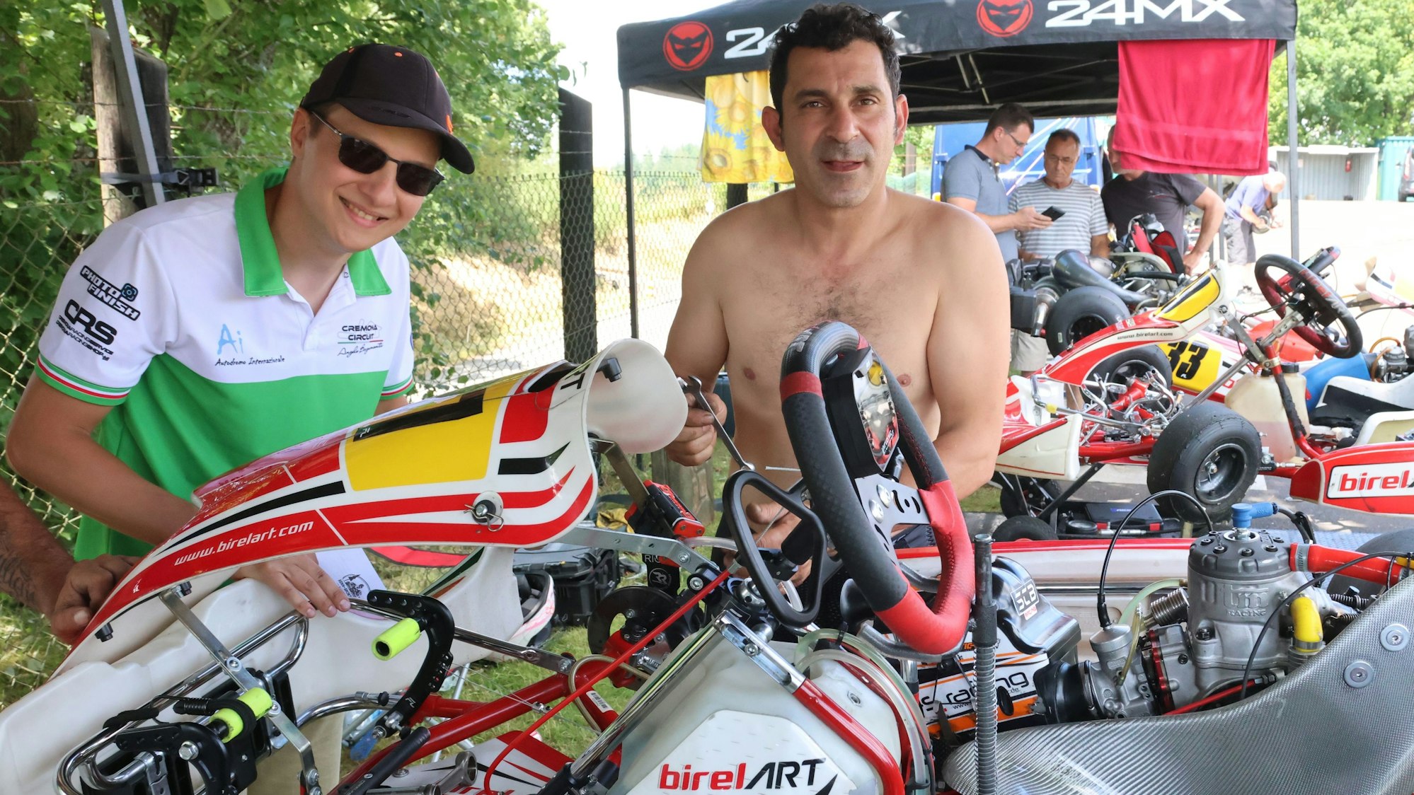 Zu sehen sind zwei Männer, die an einem Gokart herumschrauben.