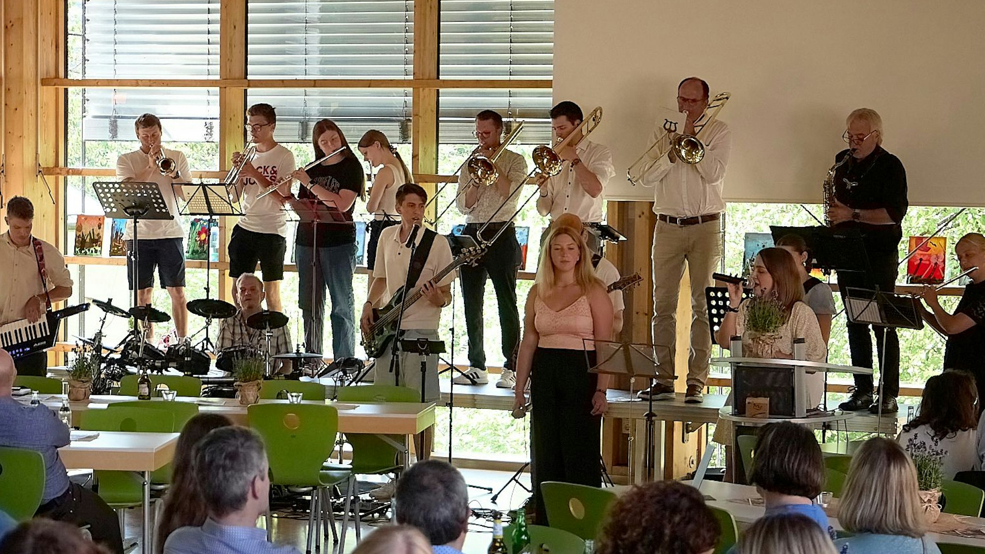 Die Band „Fettes C“ steht auf einer Bühne in der Mensa der Clara-Fey-Schule in Schleiden.