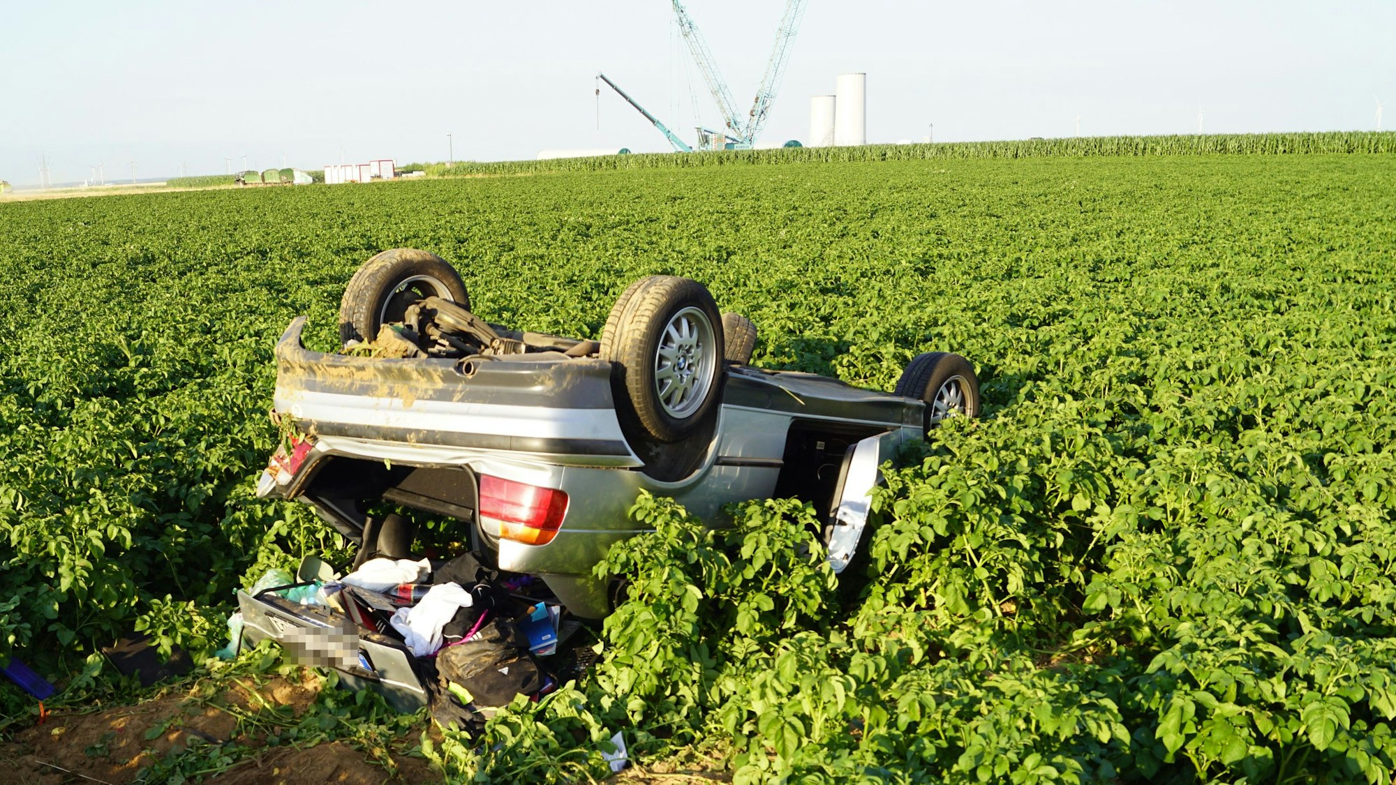 Das Bild zeigt das Auto, wie es nach dem Unfall im Feld liegt. Es ist auf dem Dach liegengeblieben.
