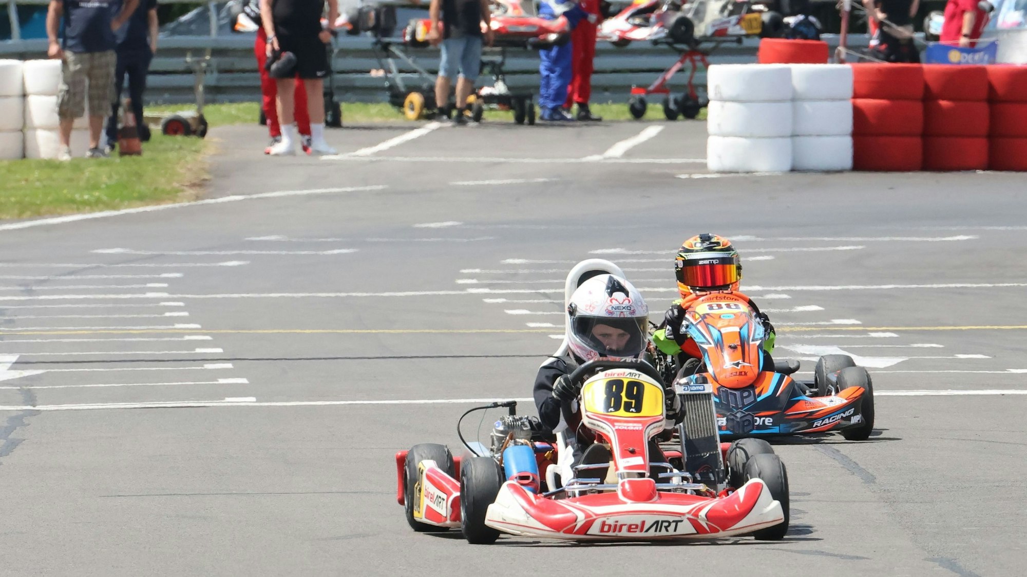 Zwei Kinder steuern ihre Karts auf einer Rennstrecke.