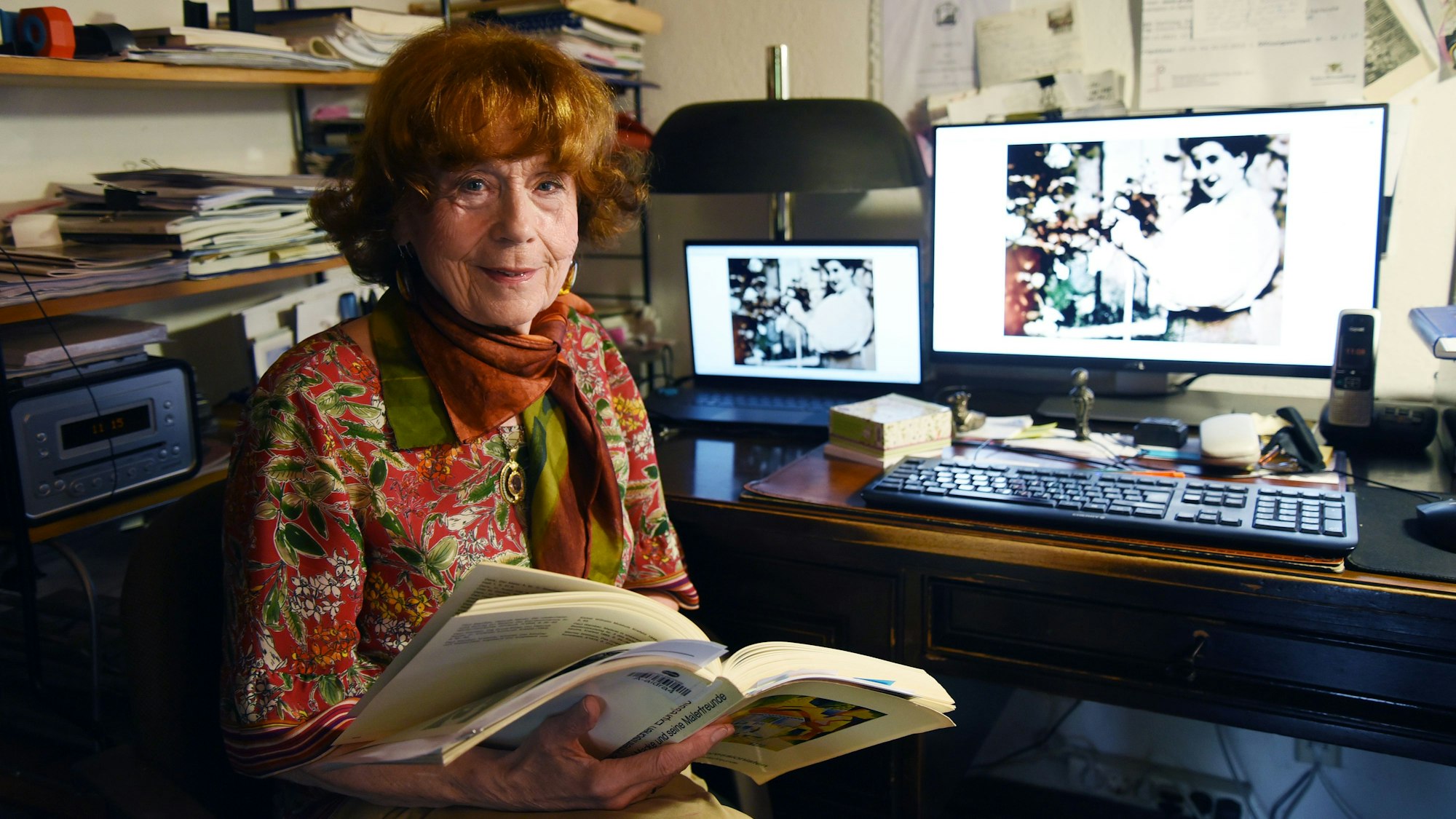 Das Foto zeigt Barbara Stewen, im Hintergrund ein Computermonitor mit einem Foto von Olga Oppenheimer.