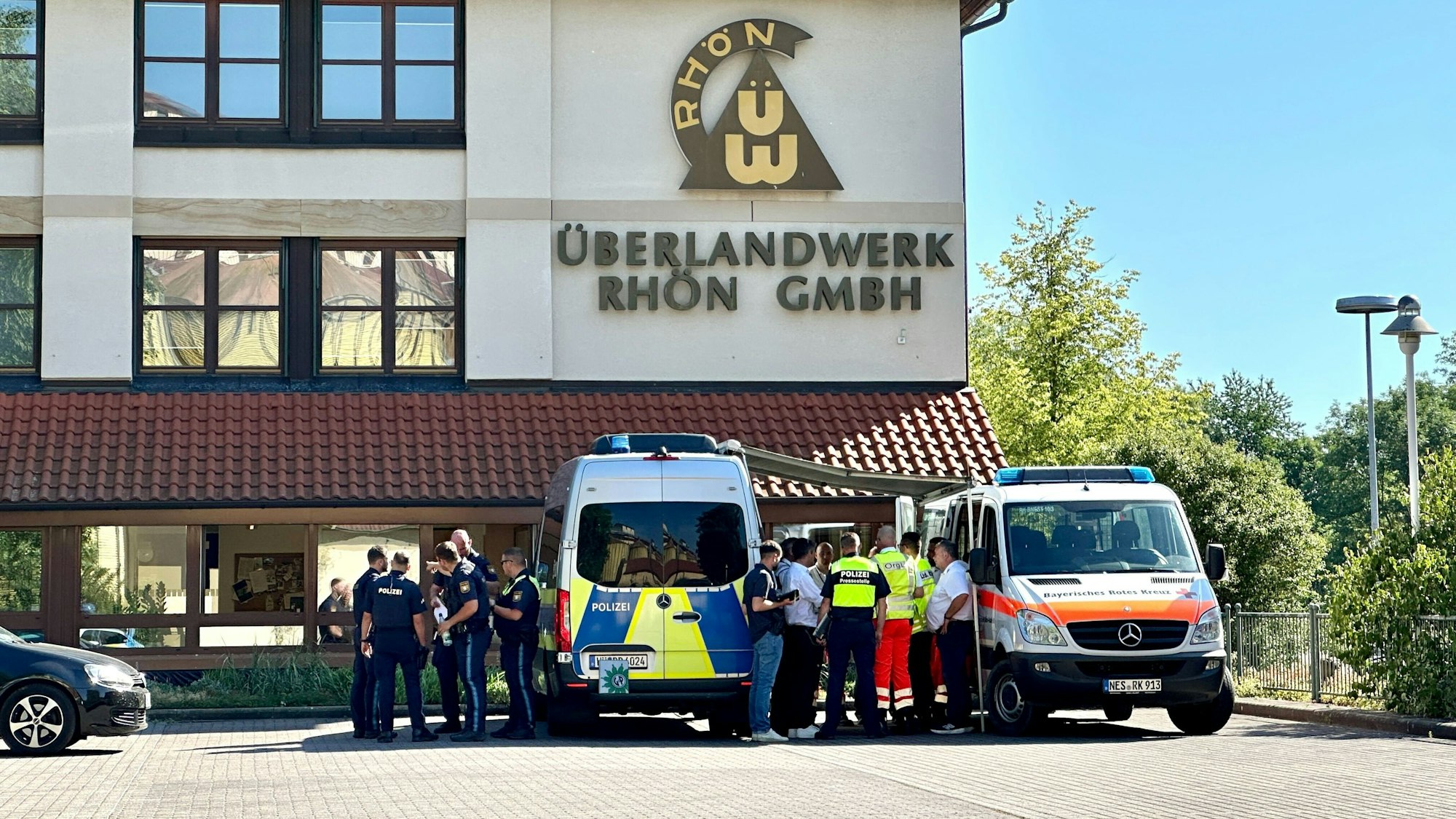 01.07.2025, Bayern, Mellrichstadt: Polizei und Rettungskräfte stehen auf dem Gelände des regionalen Netzbetreibers Überlandwerk Rhön. Ein 21-Jähriger hat in der Firma eine Kolligen getötet und zwei weitere schwer verletzt. Foto: Daniel Vogl/dpa +++ dpa-Bildfunk +++