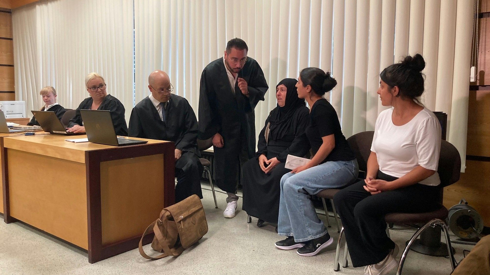 Das Bild zeigt mehrere Familienangehörigen der Opfer im Gerichtssaal.