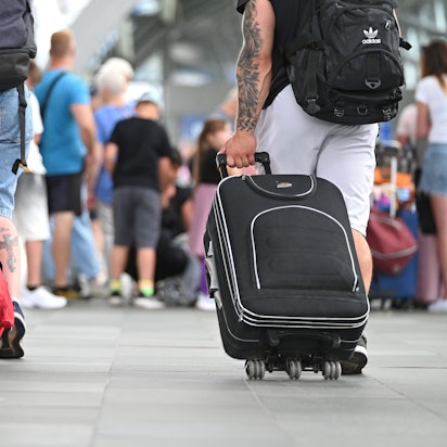 Flugreisende gehen mit Koffern durch den Flughafen Leipzig-Halle.