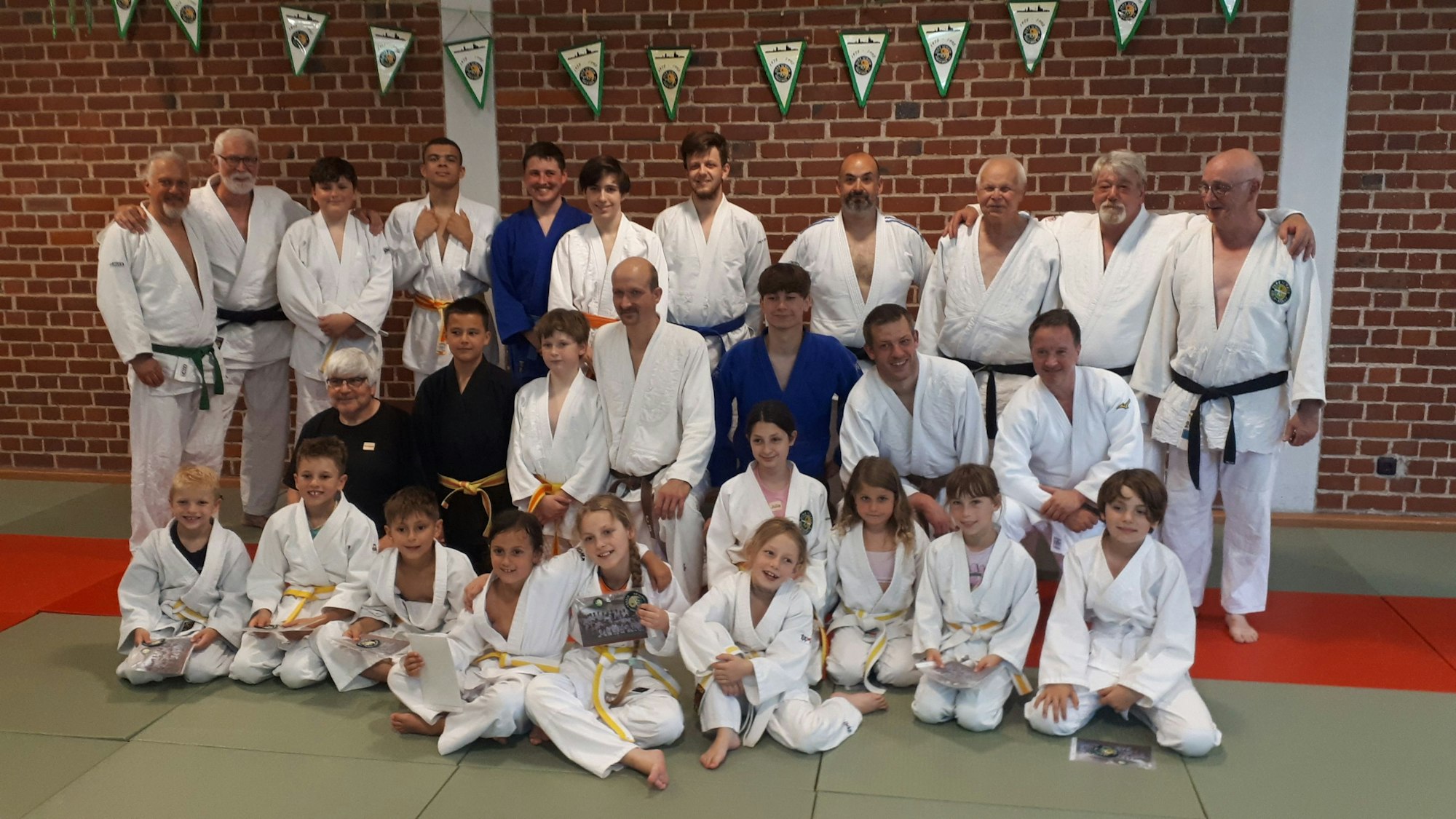 Die aktiven Mitglieder eines Judo-Vereins beim Gruppenfoto in einem Pfarrheim.