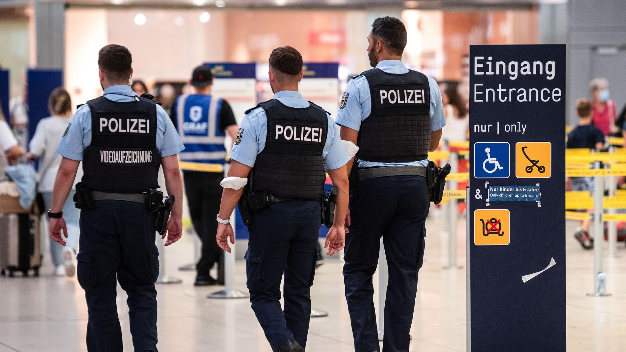 Beamte der Bundespolizei gehen an den Sicherheitskontrollen des Flughafens Köln/Bonn vorbei.