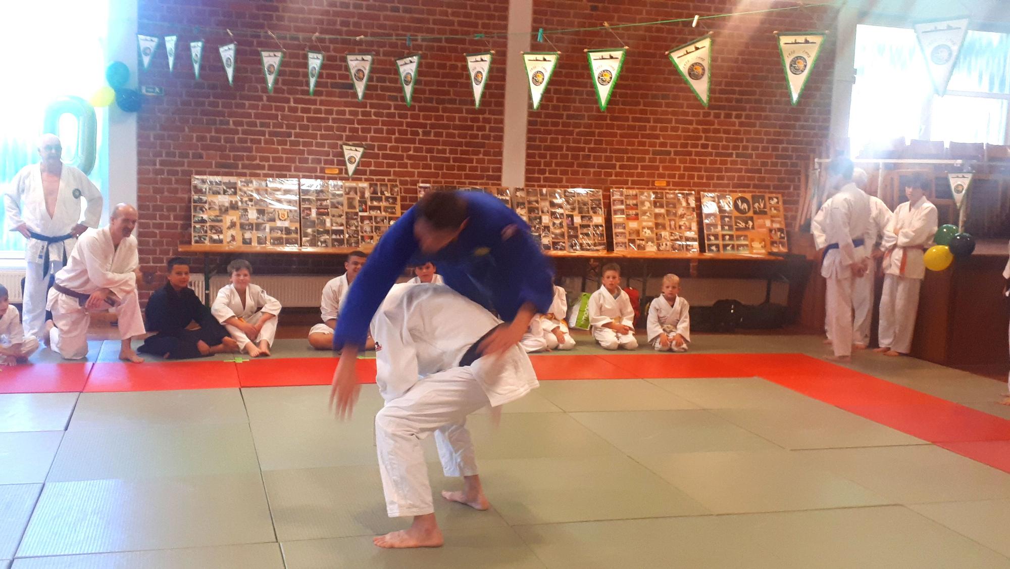 Zwei Judo-Vereinsmitglieder führen eine Wurftechnik vor.