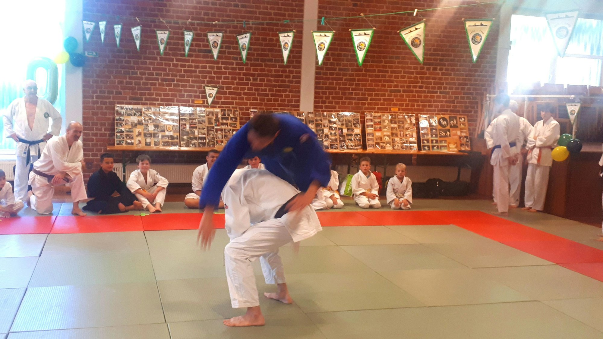 Zwei Judo-Vereinsmitglieder führen eine Wurftechnik vor.