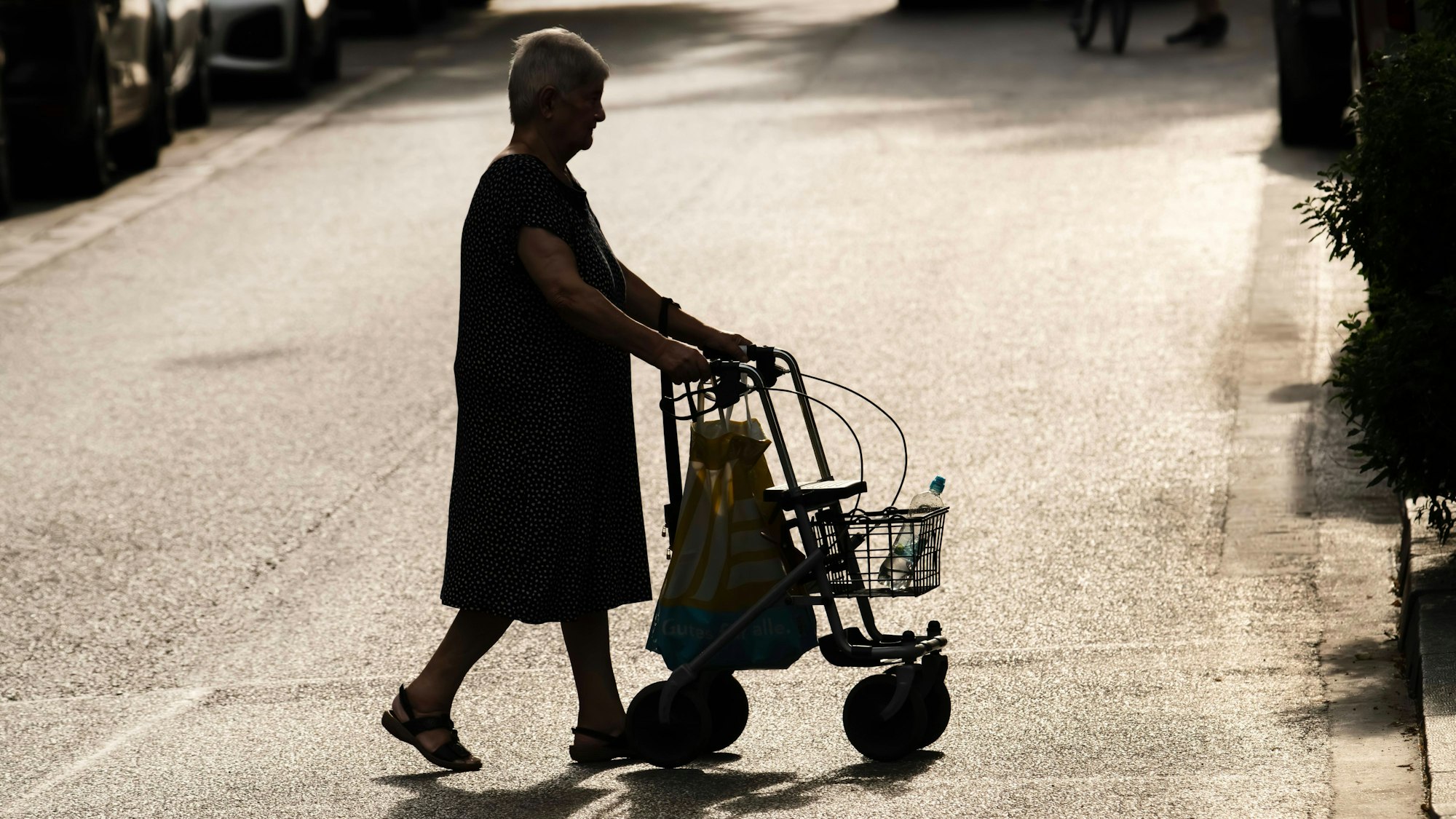 Frau mit Rollator bei Sommerhitze in der Stadt unterwegs. (Archivbild)