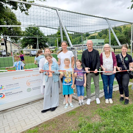 Kinder und Jugendliche sowie Vertreterinnen der beteiligten Vereine und des Kinderhilfswerks und Ingo Pfennings stehen nebeneinander hinter einem Flatterband.