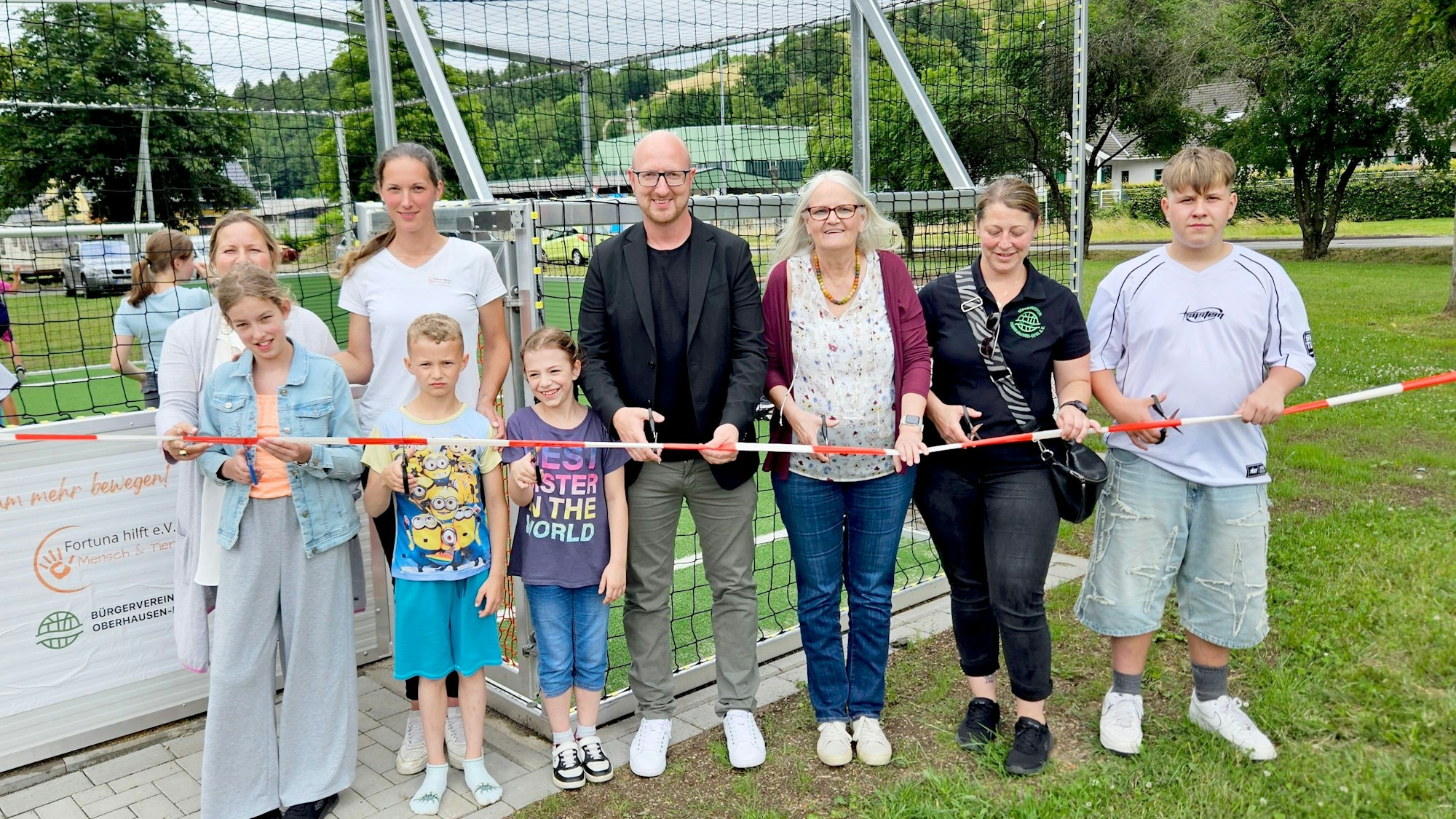 Kinder und Jugendliche sowie Vertreterinnen der beteiligten Vereine und des Kinderhilfswerks und Ingo Pfennings stehen nebeneinander hinter einem Flatterband.