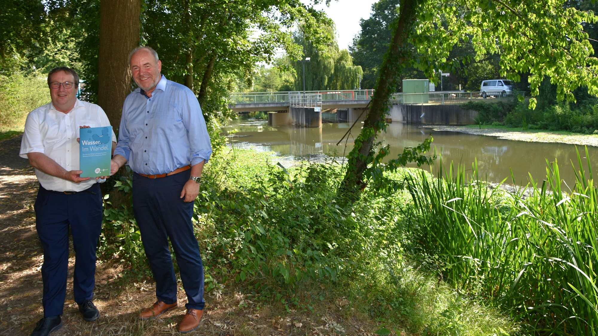 Zu sehen sind Landesumweltminister Oliver Krischer und Erftverband-Vorstand Heinrich Schäfer am Ufer der Erft.