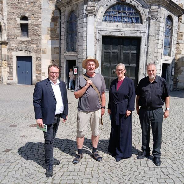 Vor der Aachener Dompforte stehen Oliver Krischer, Ralf Spilles, Sibylle Keupen und Rolf-Peter Cremer.