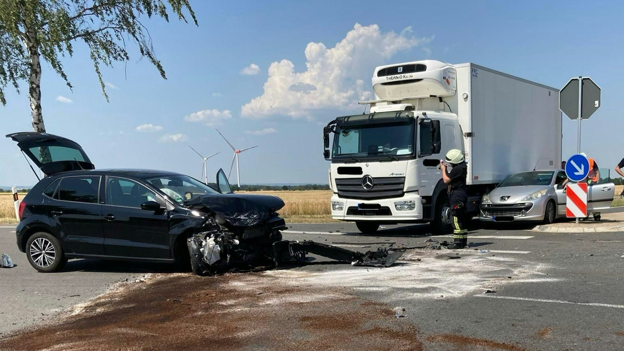 Zu sehen ist ein nach einem Unfall beschädigter schwarzer Kleinwagen.