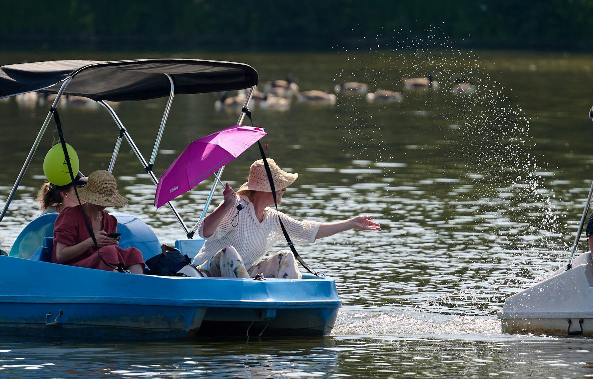 Auf dem Wasser und im Schatten ist es erträglich. Drei Frauen sind in einem Tretboot auf dem Aasee in Münster unterwegs.