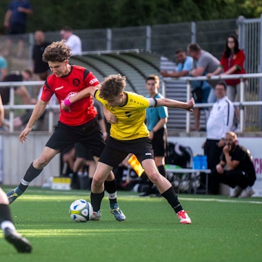 Das Bild zeigt eine Szene aus dem Hinspiel. Offensivspieler Drewniak setzt sich im Zweikampf durch.