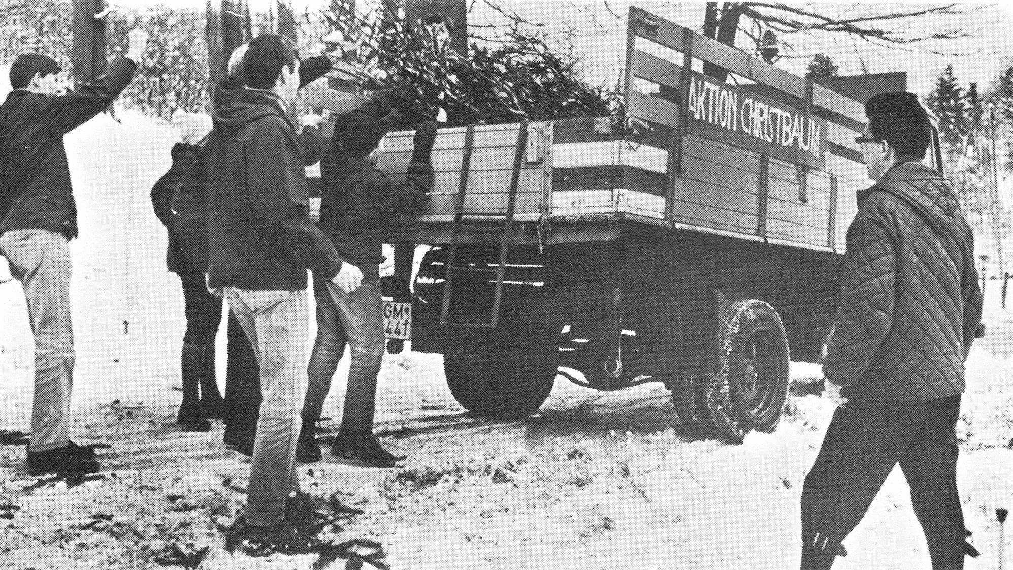 CVJM-Mitglieder wuchten in Gummersbach abgeschmückte Weihnachtsbäume zwecks Abtransport auf ein Fahrzeug.
