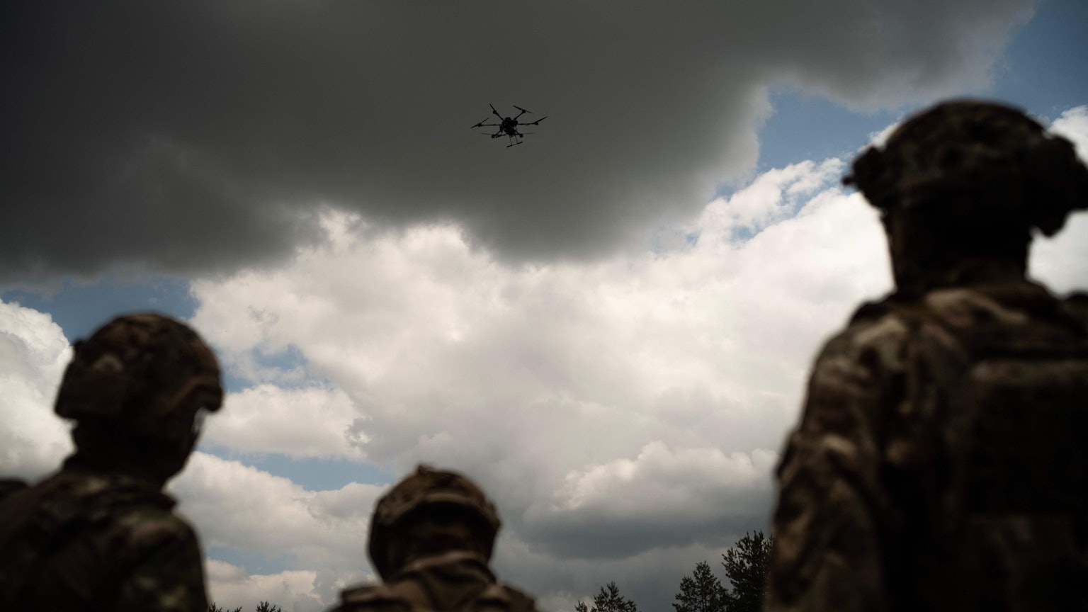 Soldiers from the "Black Sky" battalion of the Spartan brigade look at an agricultural drone, transformed into a front-line delivery cargo, during a demonstration for AFP, at an undisclosed location not far from the front line, in the region of Dnipropetrovsk, Ukraine, on June 14, 2025, amid the russian invasion of Ukraine. Ukrainian army logistics have become the priority target for Russian drones. The technological and financial growth of the Russian drone industry is forcing the Ukrainian army to adapt by building new means of transport and logistical deliveries, such as buggies, motorbikes and cargo delivery drones, using whatever resources are available. (Photo by Florent VERGNES / AFP)