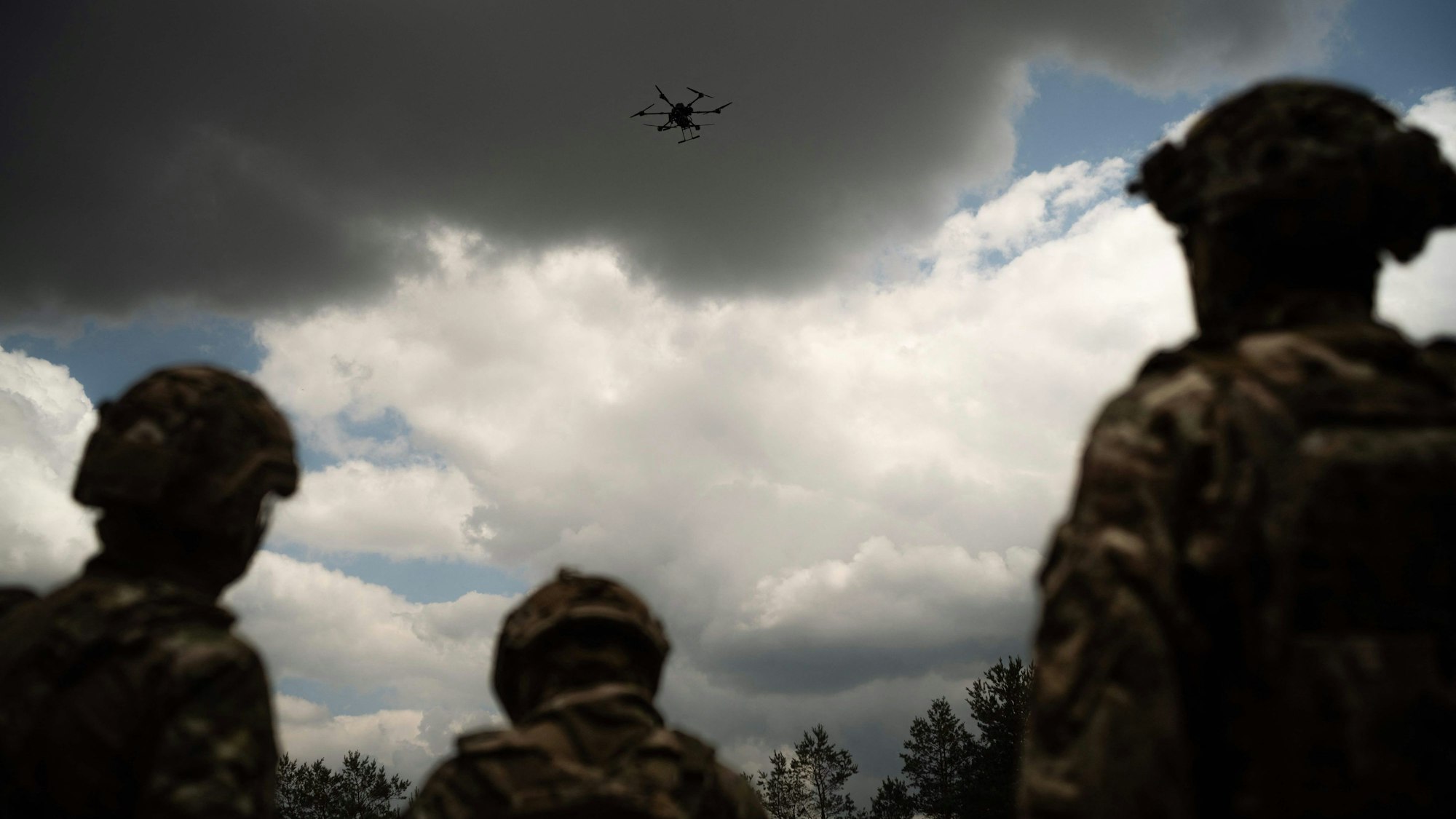Soldiers from the "Black Sky" battalion of the Spartan brigade look at an agricultural drone, transformed into a front-line delivery cargo, during a demonstration for AFP, at an undisclosed location not far from the front line, in the region of Dnipropetrovsk, Ukraine, on June 14, 2025, amid the russian invasion of Ukraine. Ukrainian army logistics have become the priority target for Russian drones. The technological and financial growth of the Russian drone industry is forcing the Ukrainian army to adapt by building new means of transport and logistical deliveries, such as buggies, motorbikes and cargo delivery drones, using whatever resources are available. (Photo by Florent VERGNES / AFP)
