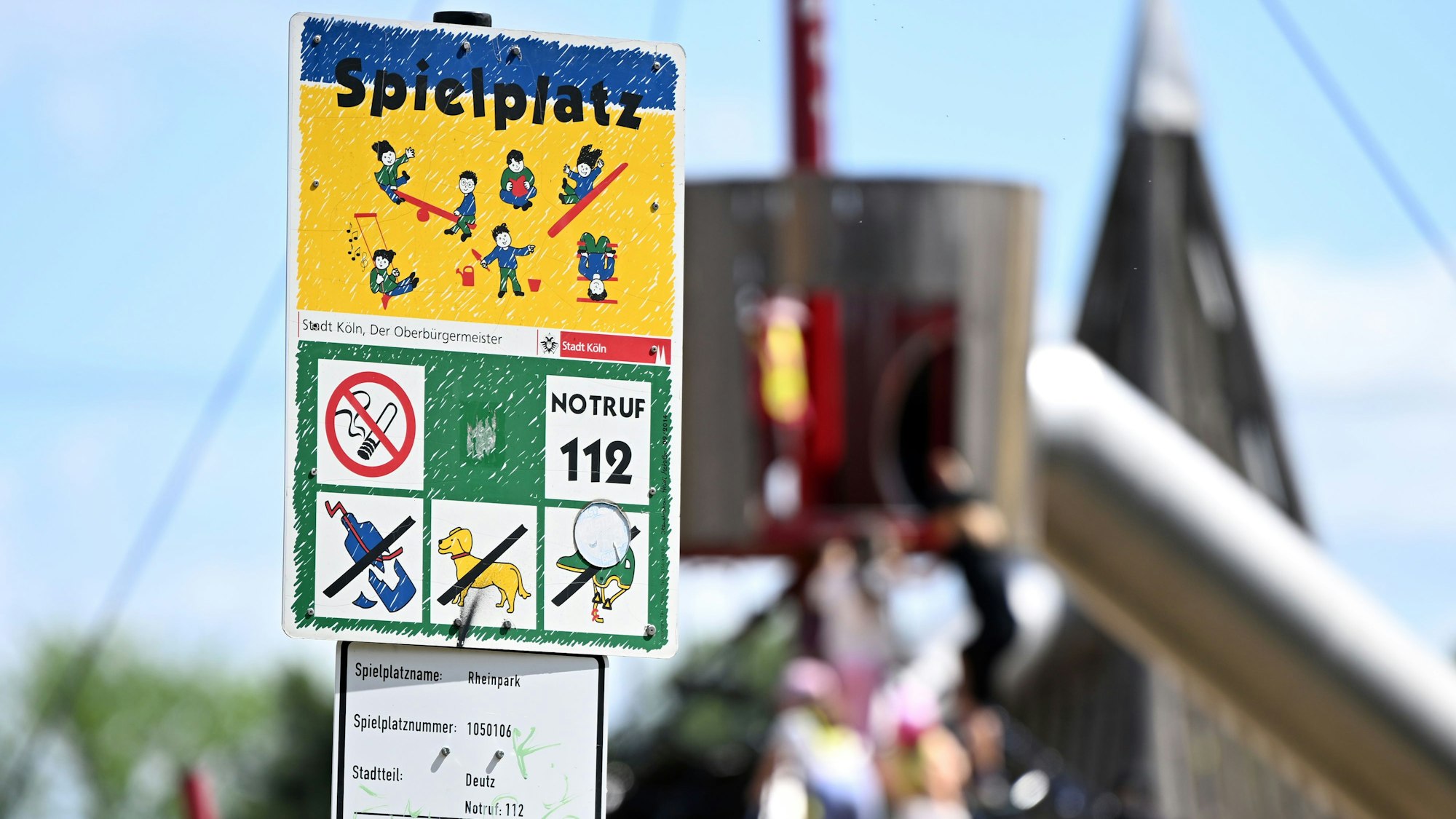 Ein Schild weist auf einen Spielplatz hin.