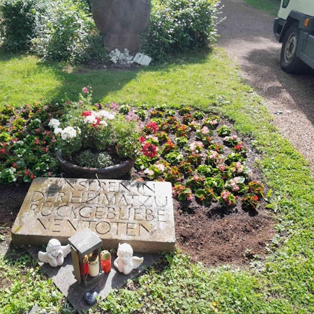 Auf dem Bild ist ein bepflanztes Ehrenmal zu sehen.