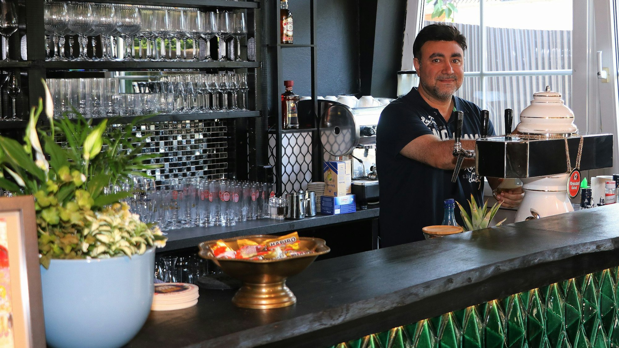 Auf dem Bild ist der Inhaber hinter der Theke des neuen Restaurants zu sehen.